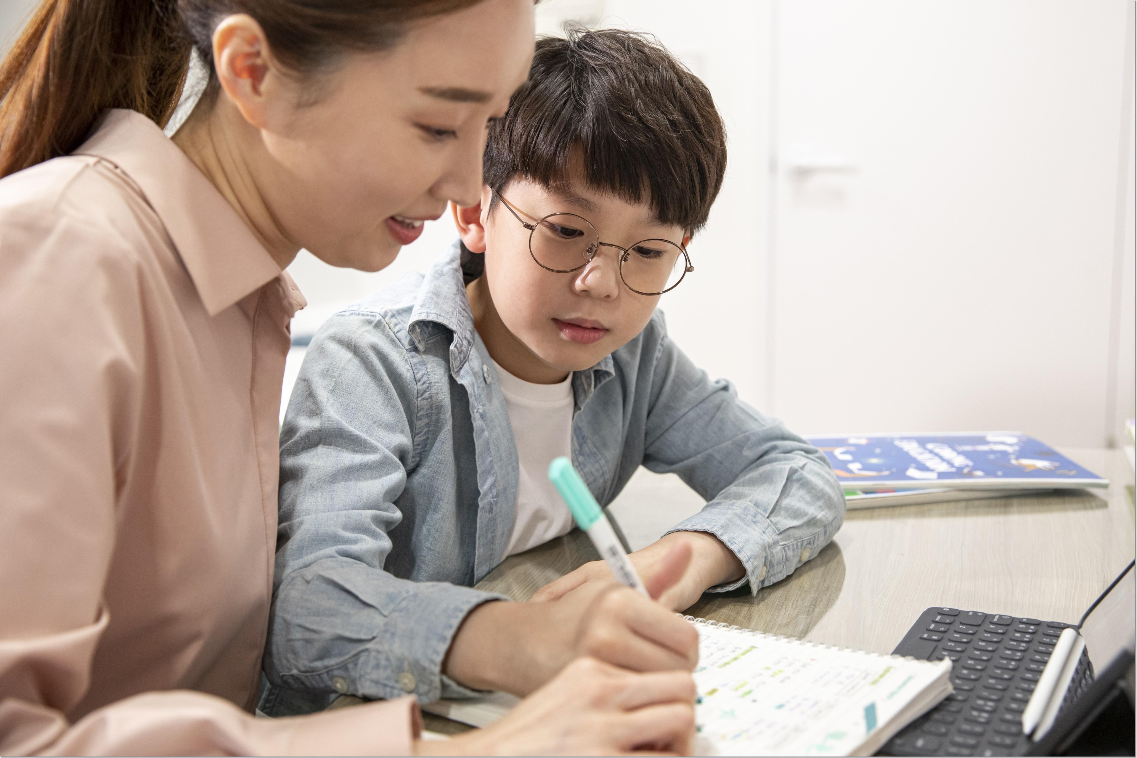 학생과 교재를 함께 살펴보는 성인
