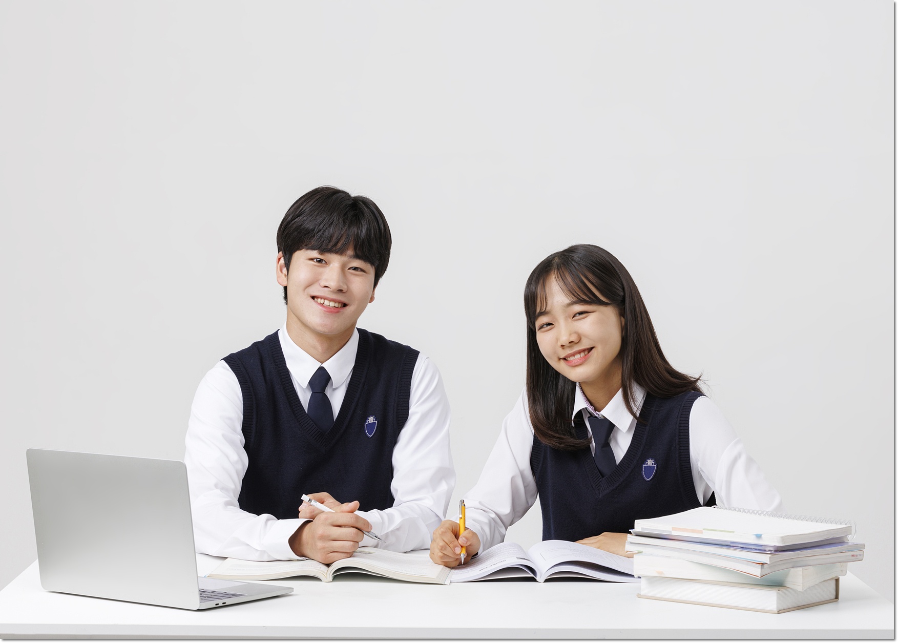 책상에서 함께 자료를 보는 두 학생