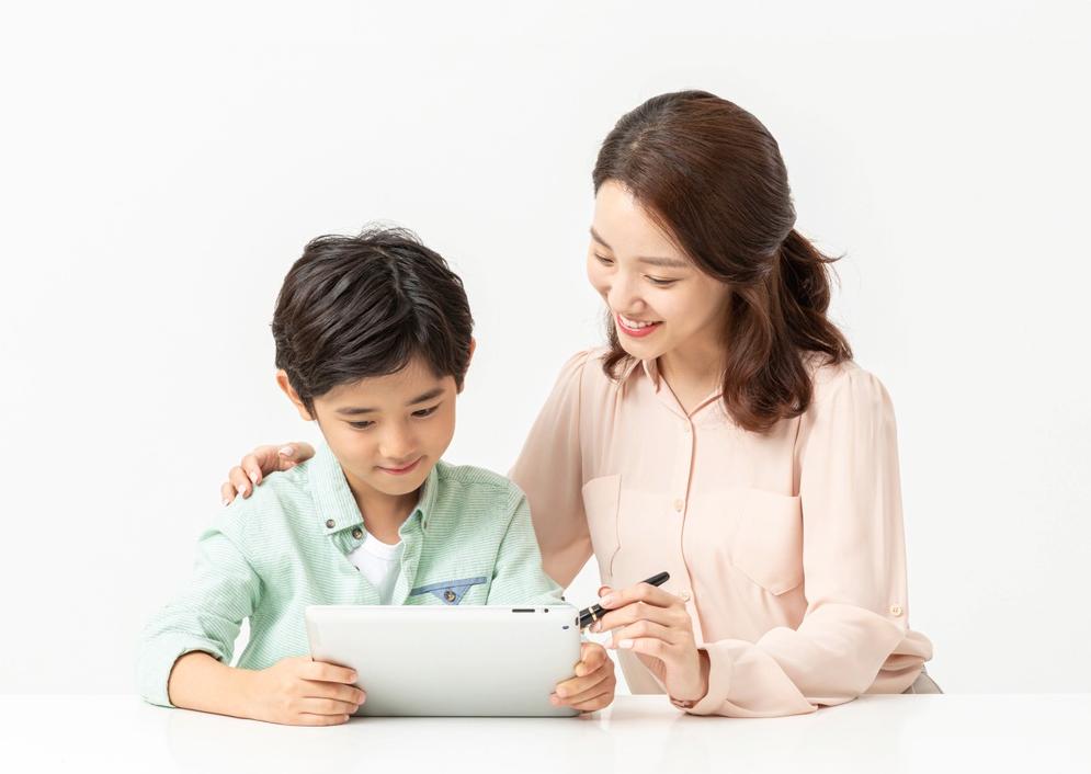 태블릿을 함께 살펴보는 성인과 학생