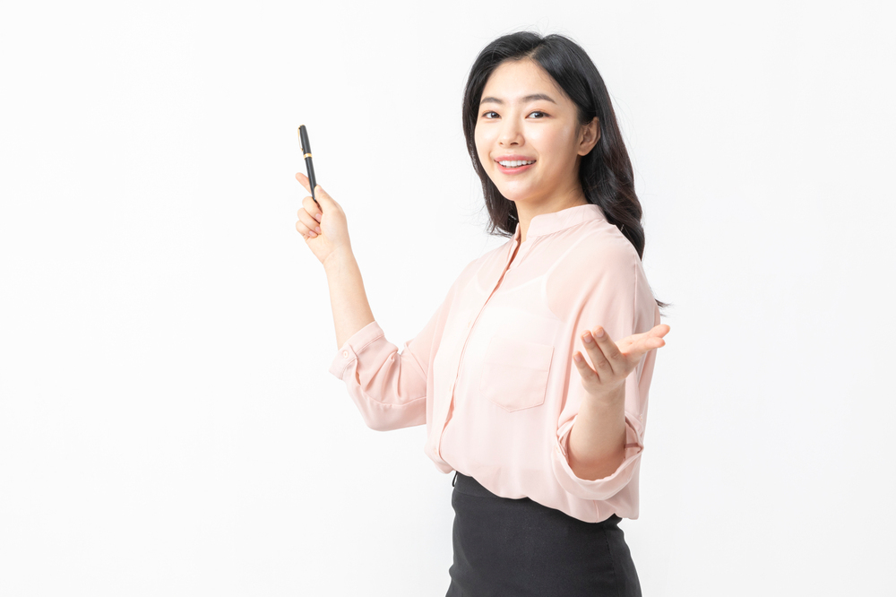 펜과 교재를 들고 설명하는 성인